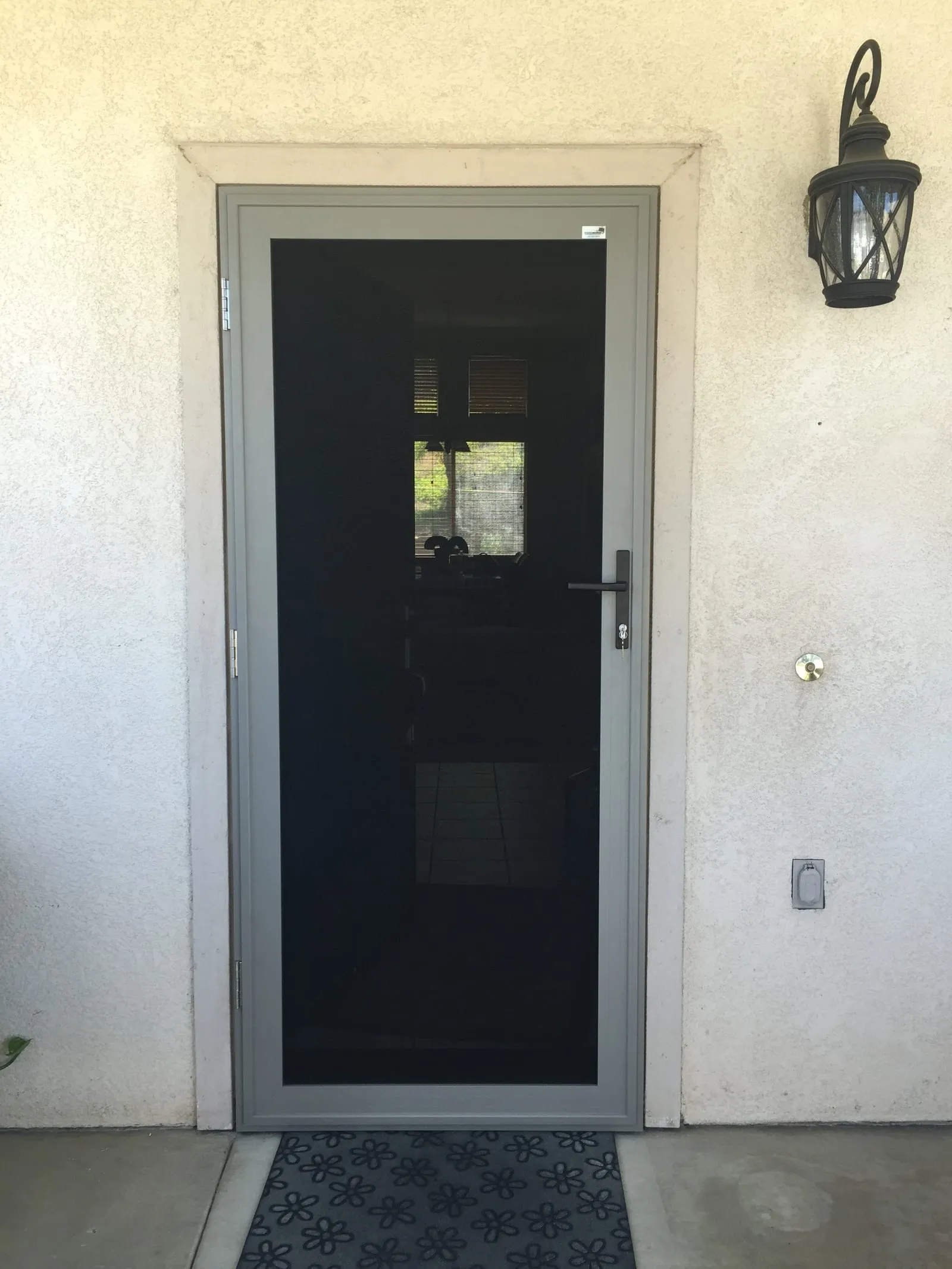 Gray hinged security screen door with clear sightline through to the entry hall