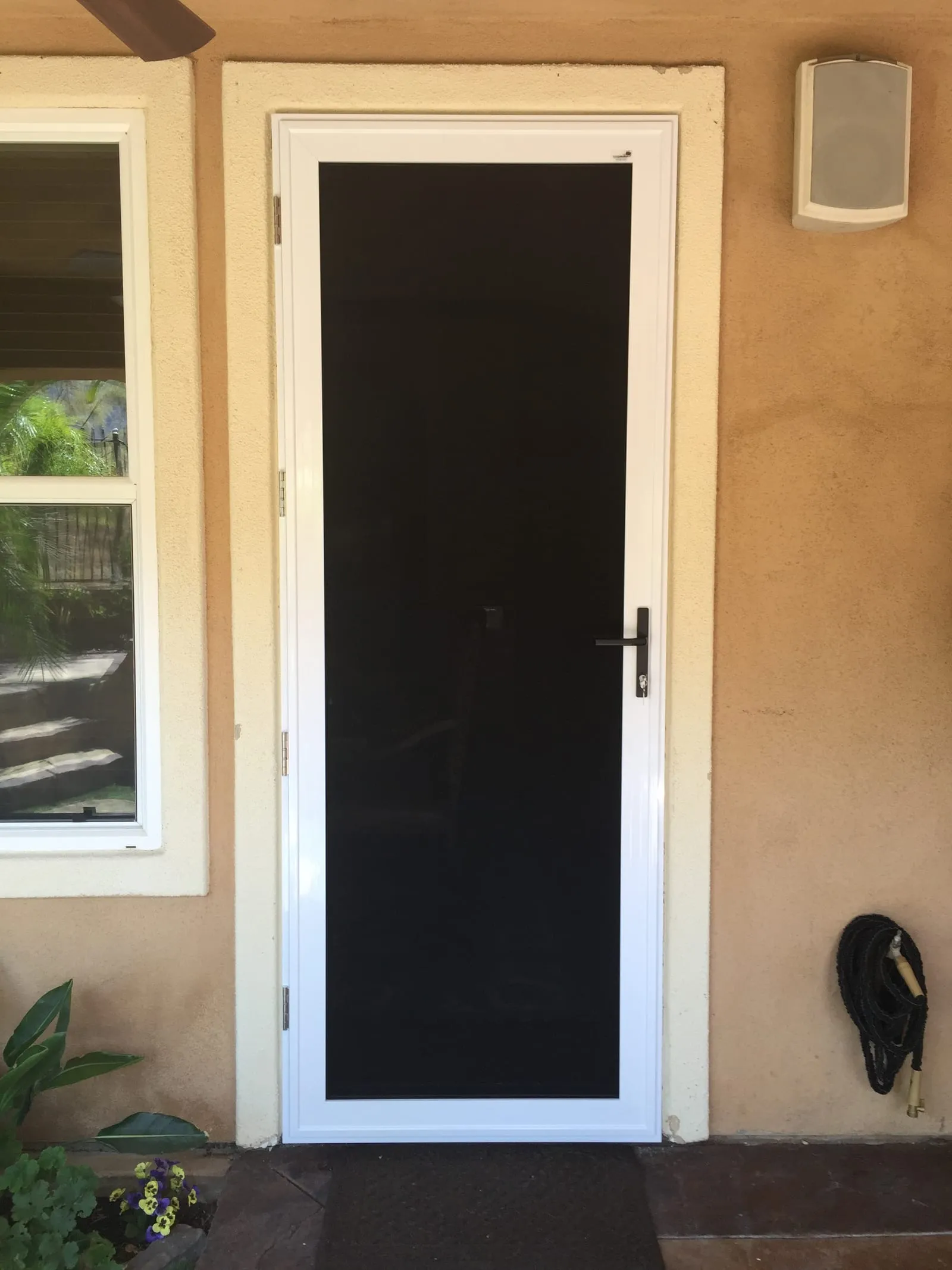 White security screen door installed beside a patio slider