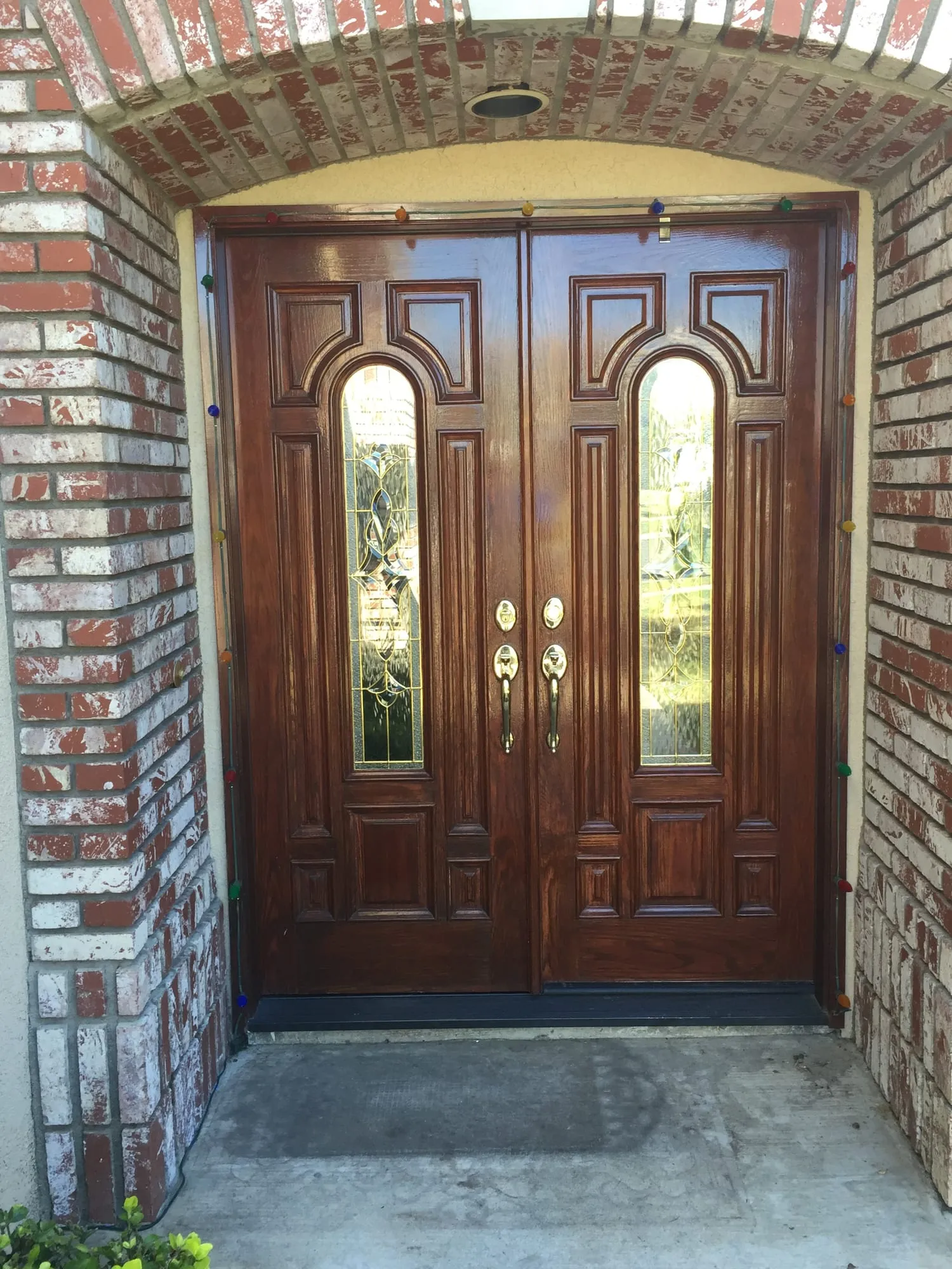 The same brick-arched entry before installation - wooden double doors that stayed closed